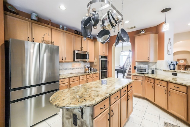 kitchen featuring a center island, backsplash, stainless steel appliances, and light stone countertops