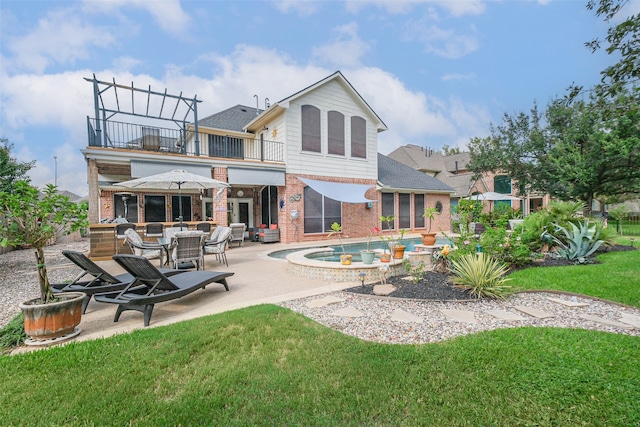 rear view of property featuring a yard, a jacuzzi, a patio area, and a balcony