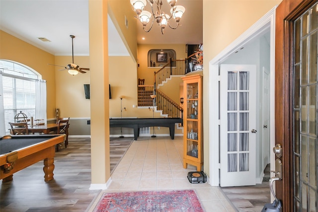 entrance foyer with light hardwood / wood-style flooring, ornamental molding, and ceiling fan with notable chandelier