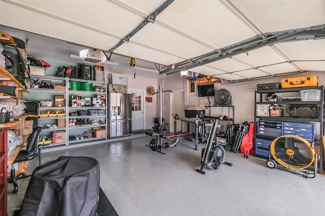 garage with stainless steel fridge and a garage door opener