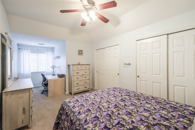 carpeted bedroom featuring ceiling fan and multiple closets