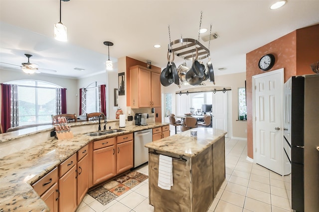 kitchen featuring hanging light fixtures, stainless steel appliances, sink, ceiling fan, and light stone countertops