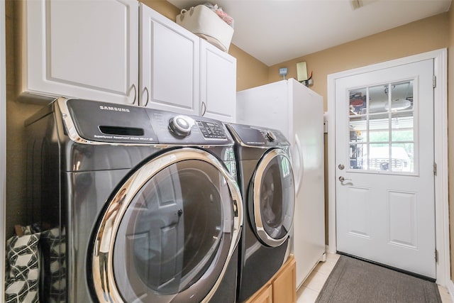 laundry room featuring cabinets, washing machine and clothes dryer, and light tile patterned flooring