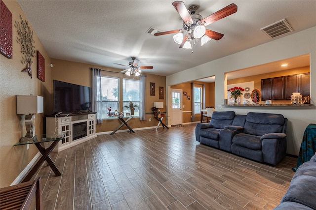 living room featuring a textured ceiling, ceiling fan, and hardwood / wood-style floors