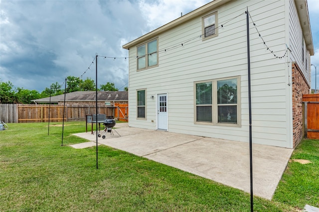 back of property with a lawn and a patio area