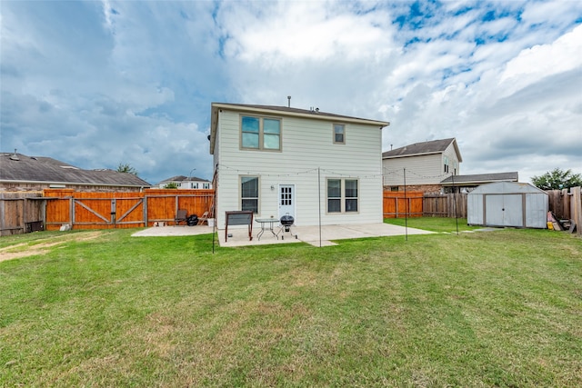 rear view of house featuring a yard, a patio, and a shed