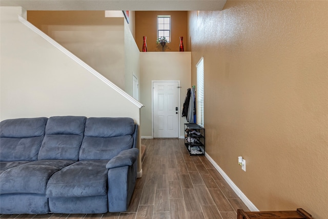 living room featuring dark wood-type flooring and a towering ceiling