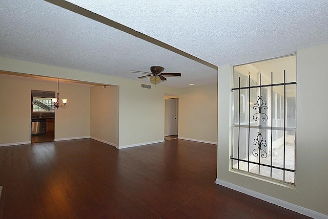 unfurnished room featuring ceiling fan with notable chandelier, dark hardwood / wood-style flooring, and a textured ceiling