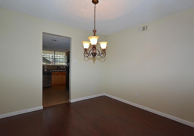 unfurnished dining area featuring a textured ceiling, a notable chandelier, sink, and dark hardwood / wood-style flooring