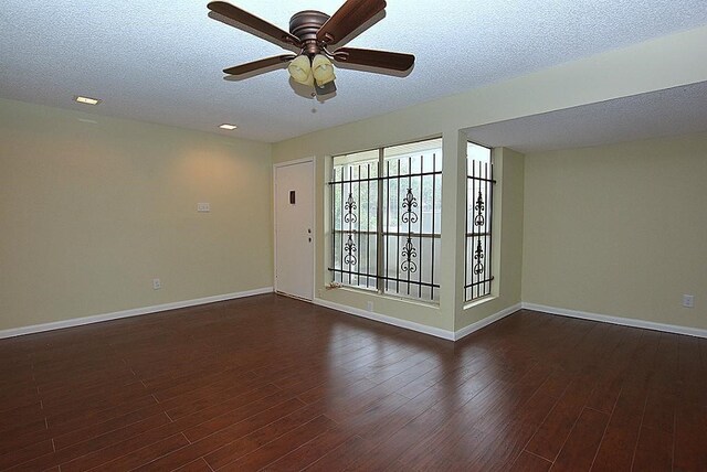 empty room with a textured ceiling, dark wood-type flooring, and ceiling fan