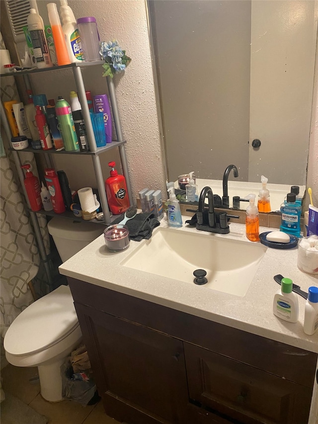 bathroom featuring vanity, toilet, and tile patterned floors