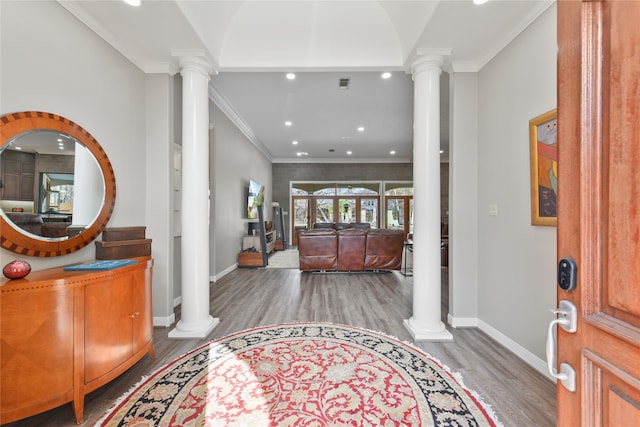 foyer entrance with hardwood / wood-style flooring, ornamental molding, and ornate columns