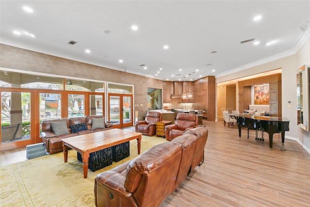 living room featuring crown molding, french doors, and light hardwood / wood-style flooring