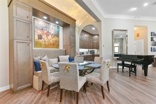 dining space featuring crown molding and light hardwood / wood-style flooring