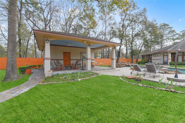 view of yard featuring ceiling fan and a patio