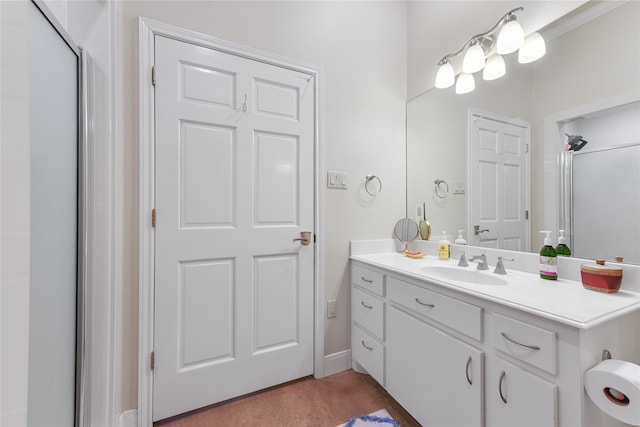 bathroom featuring a shower with door and vanity