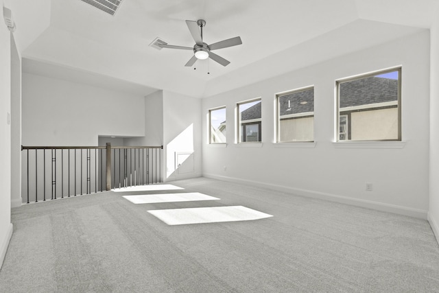 carpeted empty room with ceiling fan and a tray ceiling