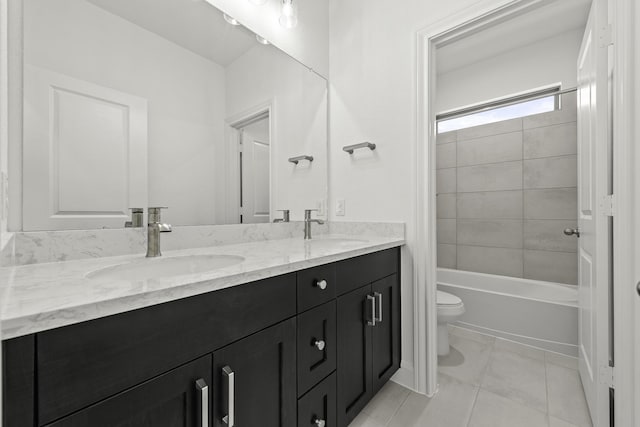 full bathroom with tile patterned flooring, vanity, tiled shower / bath, and toilet