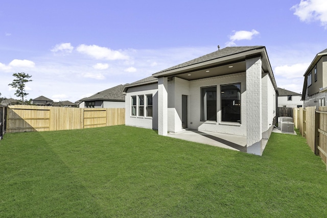 back of property featuring central AC unit, a patio area, and a lawn