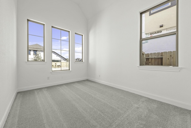 carpeted empty room with lofted ceiling