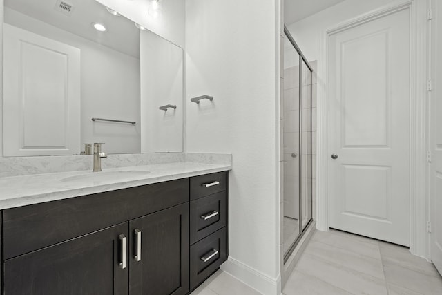 bathroom with tile patterned floors, a shower with shower door, and vanity