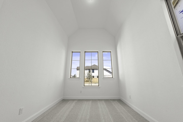 carpeted spare room with lofted ceiling