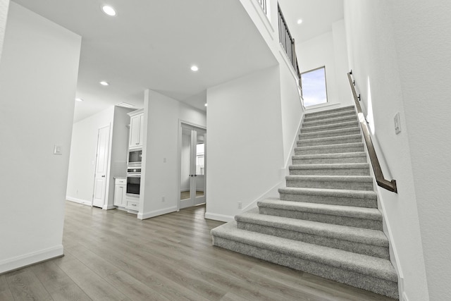 stairs featuring hardwood / wood-style floors