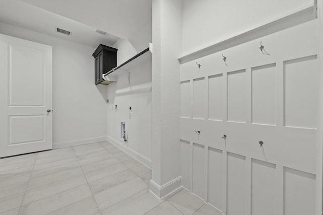 washroom with electric dryer hookup, cabinets, hookup for a gas dryer, and light tile patterned floors