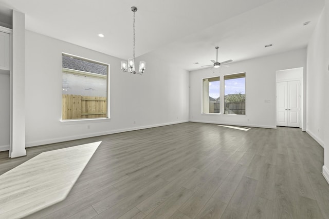 interior space featuring hardwood / wood-style floors and ceiling fan with notable chandelier