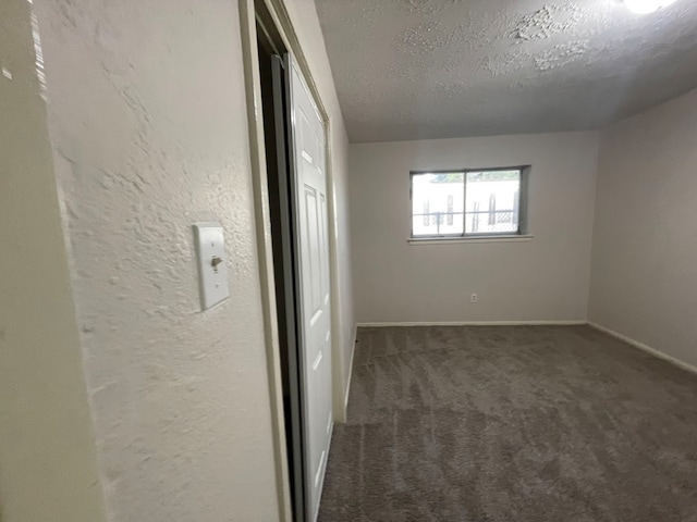 empty room with a textured ceiling and carpet