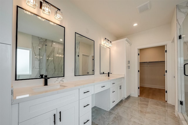 bathroom with vanity and a shower with door