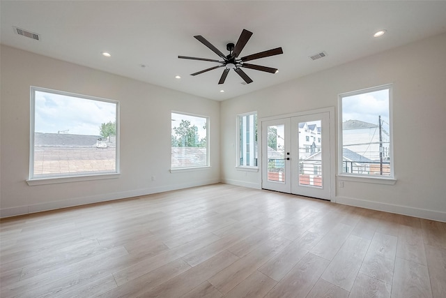 unfurnished room with ceiling fan, french doors, and light wood-type flooring