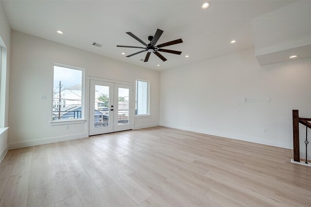 unfurnished living room with ceiling fan, french doors, and light hardwood / wood-style flooring