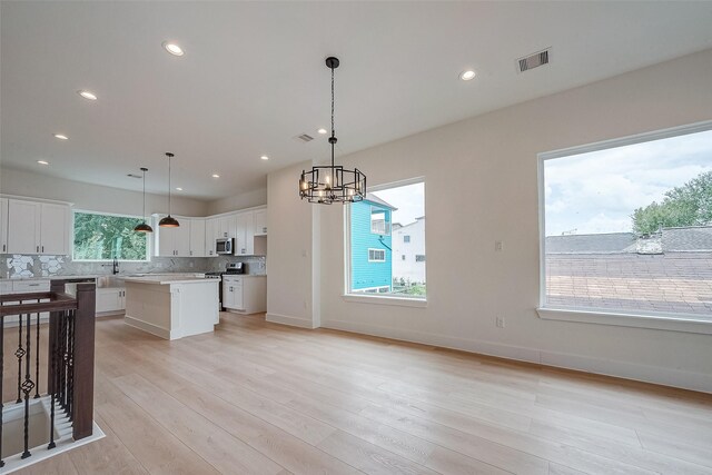 kitchen with plenty of natural light, decorative light fixtures, and a kitchen island