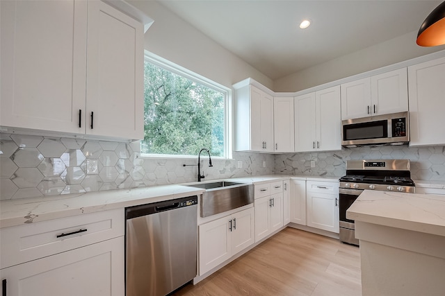 kitchen featuring light wood-type flooring, white cabinetry, sink, and stainless steel appliances