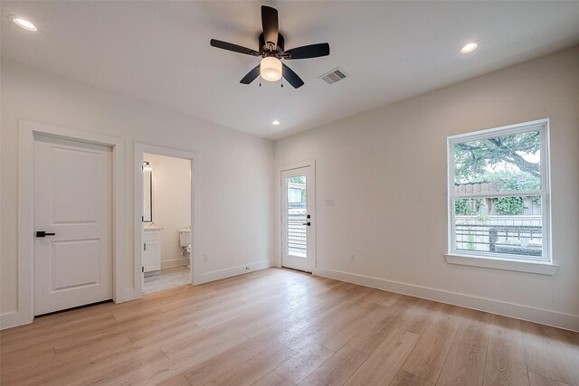 empty room featuring ceiling fan, light wood-type flooring, and a healthy amount of sunlight