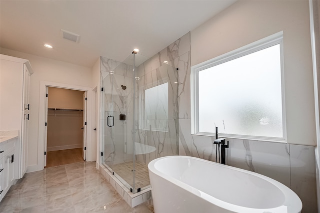 bathroom featuring vanity and shower with separate bathtub