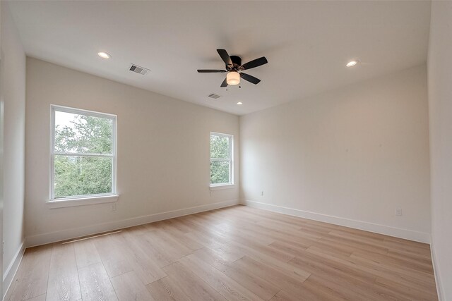 unfurnished room with ceiling fan, light wood-type flooring, and a wealth of natural light