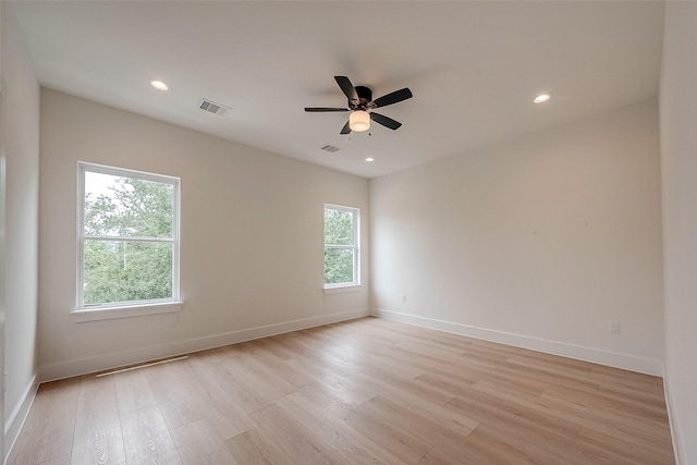 spare room featuring ceiling fan, light hardwood / wood-style flooring, and plenty of natural light