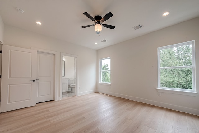 unfurnished bedroom featuring light hardwood / wood-style floors, ensuite bath, and ceiling fan