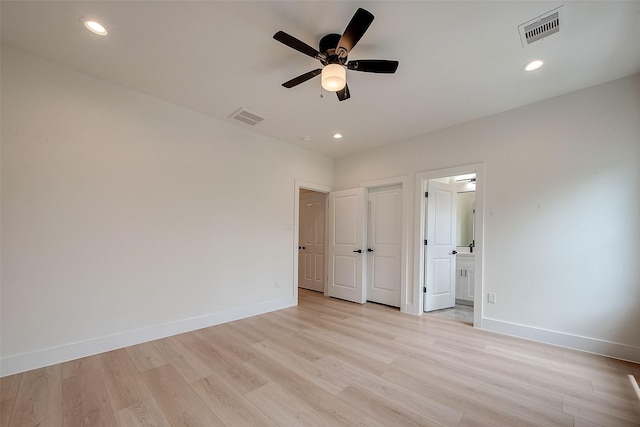 unfurnished bedroom with light wood-type flooring, ceiling fan, and connected bathroom