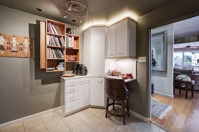 kitchen featuring ceiling fan, light wood-type flooring, and white cabinetry