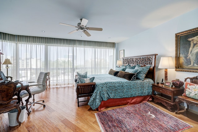 bedroom featuring multiple windows, ceiling fan, and light hardwood / wood-style flooring