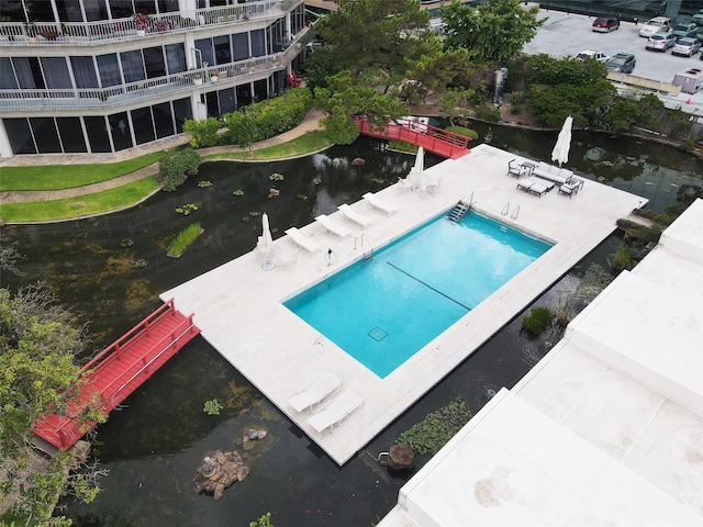 view of swimming pool featuring a water view and a patio