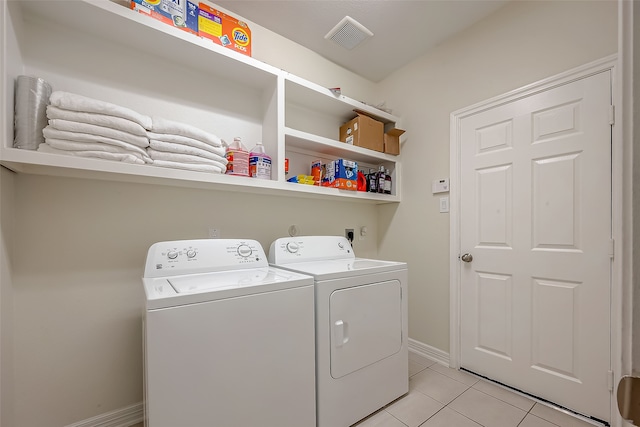 washroom with light tile patterned floors and washer and clothes dryer