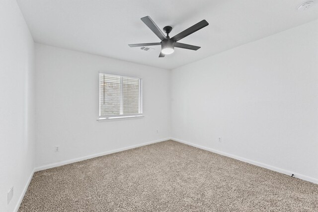 empty room featuring ceiling fan and carpet