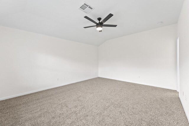 spare room featuring lofted ceiling, carpet flooring, and ceiling fan