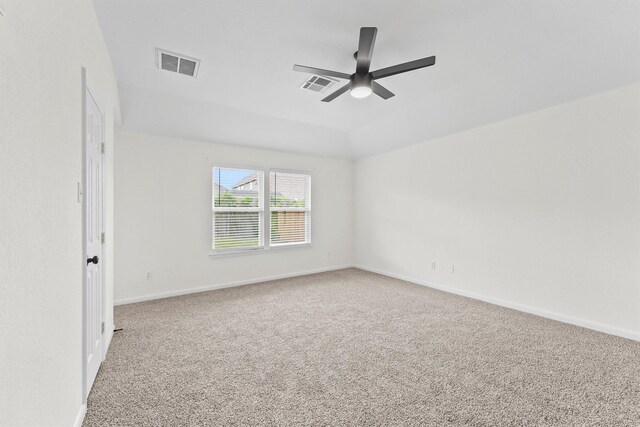 carpeted spare room featuring ceiling fan, visible vents, and baseboards