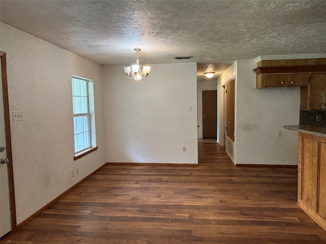 unfurnished dining area with a textured ceiling, dark hardwood / wood-style floors, and a notable chandelier