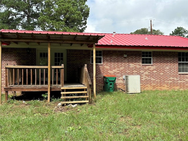 back of property featuring a wooden deck, a yard, and central AC unit